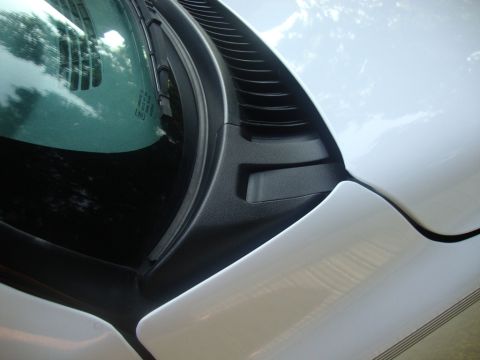 2002 Chevrolet Silverado 1500 - Close-up view of the windshield wiper cowl and hood area of a white vehicle, showing black trim and vent details.
