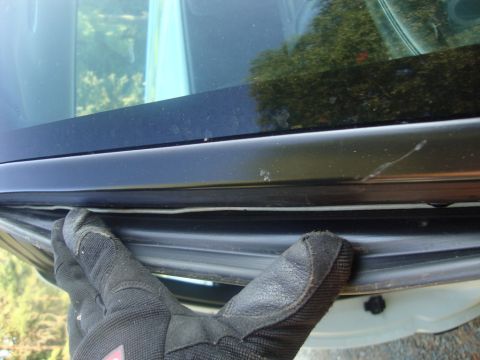 2002 Chevrolet Silverado 1500 - Gloved hand is shown pulling weather stripping from a car door frame.
