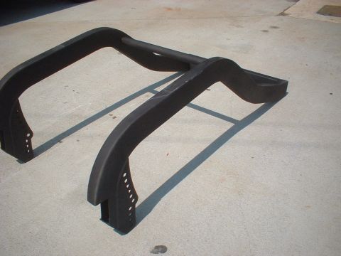 1969 Ford Torino - A black roll bar, likely for an off-road vehicle, is shown on a concrete surface. The part features mounting brackets and perforated sectio…