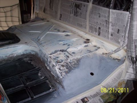 1973 Ford F-250 - The floor of a vehicle interior is shown, covered in primer and protected by newspaper.