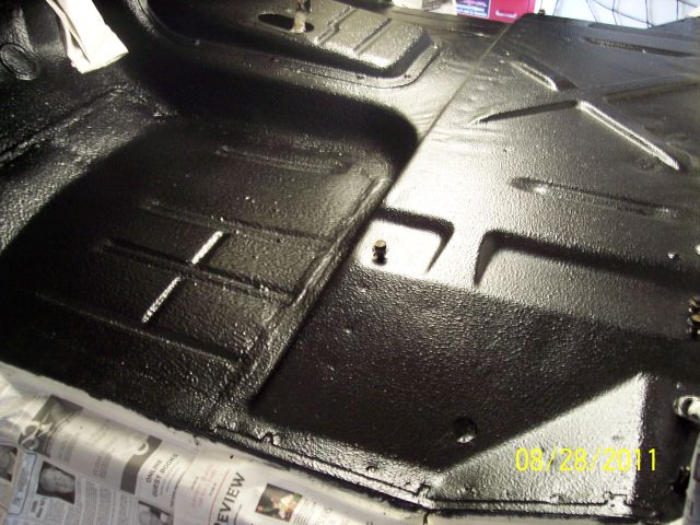 Black painted truck floor pan with textured surface and visible bolts