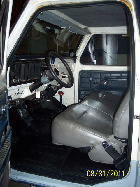 1973 Ford F-250 - The interior of a 1973 Ford F-250 shows a gray bench seat and dashboard details.