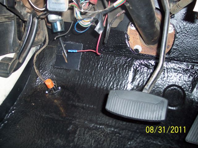 Truck driver footwell with black-painted floor, gas pedal, floor dimmer switch and dash wiring