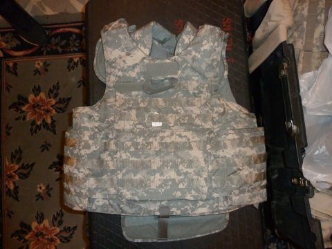1992 Ford Mustang - Body armor with digital camouflage pattern is laid out on a patterned rug.