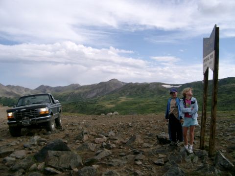 1995 Ford Bronco - A 1995 Ford F-150 pickup truck is parked on a rocky mountain trail with two children looking at a signpost.