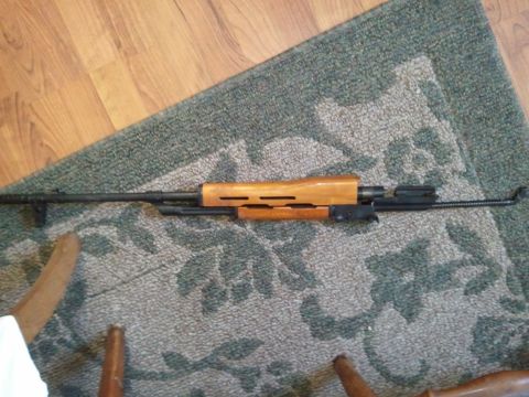 1985 Ford F-150 - A rifle part with a wooden handguard is visible on a patterned rug.