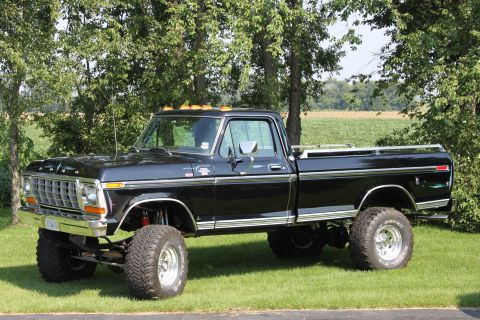 1979 Ford F-250 - This lifted 1979 Ford F-250 pickup truck is parked on a grassy lawn with trees behind it.