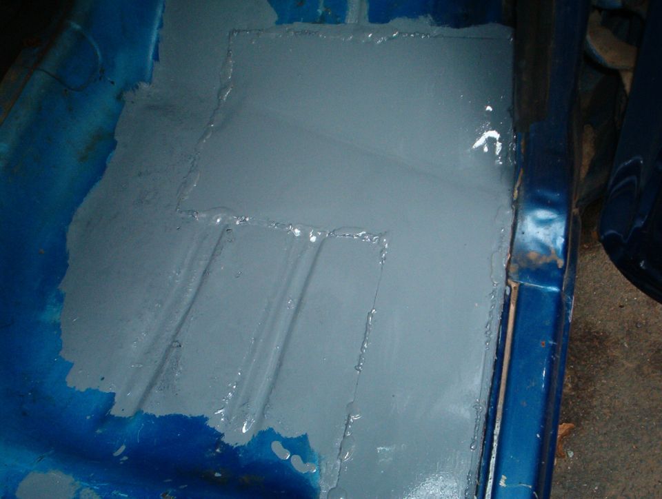 New floor pan patch panel welded in and painted gray primer inside blue Bronco body