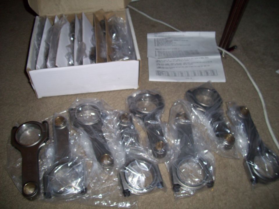 Box of engine connecting rods, some individually wrapped, with instructions