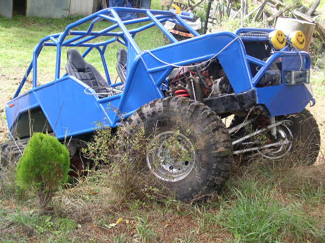 Blue off-road buggy with roll cage and smiley face headlights