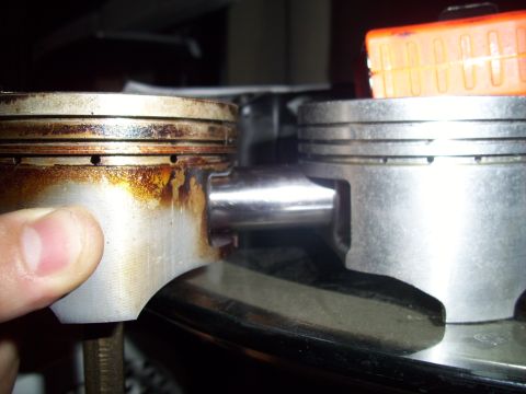 1995 Ford Probe - Comparison of a used piston with carbon buildup next to a clean piston.