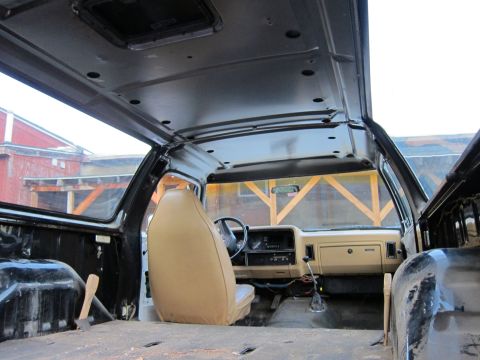 1987 Dodge 1500 - The interior of a 1987 Dodge 1500 pickup truck is shown, a tan seat and dashboard, with the interior stripped down.