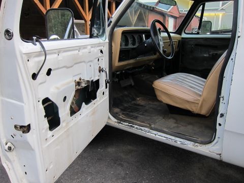 1987 Dodge 1500 - The interior of a Dodge Ram pickup truck, with the driver's side door panel removed, revealing the inner workings.