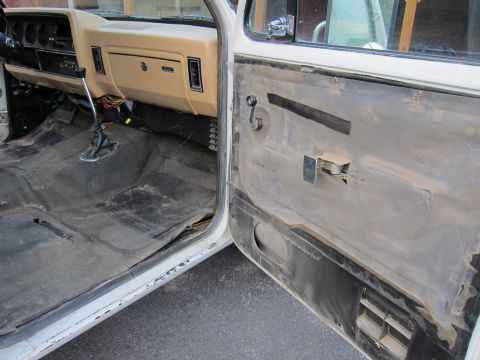 1987 Dodge 1500 - Interior view of a 1987 Dodge 1500 pickup truck, revealing the dashboard, floor, and door panel in a state of disassembly.