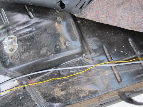 1987 Dodge 1500 - Close-up view of the dirty interior floor and wiring in a vehicle.