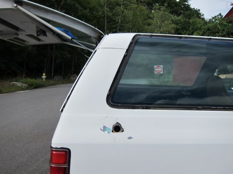 1987 Dodge 1500 - Airplane wing extends over the rear of a white SUV parked outdoors.