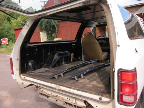 1987 Dodge 1500 - The interior of a 1987 Dodge 1500 pickup truck is visible with the tailgate open, revealing the cargo bed and a portion of the cabin.