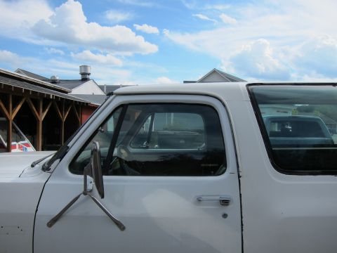 1987 Dodge 1500 - A white 1987 Dodge 1500 pickup truck is seen from the side, with another vehicle visible in the background.
