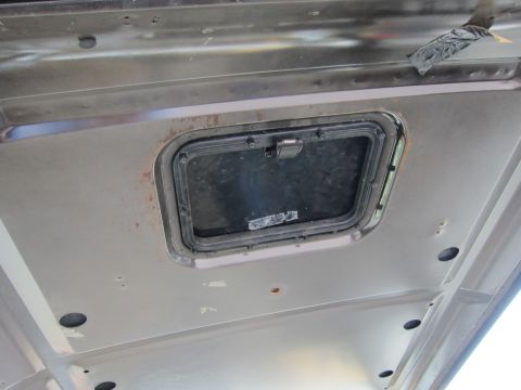 1987 Dodge 1500 - Close-up view of the interior roof panel, showing a small, dark window with a latch mechanism.