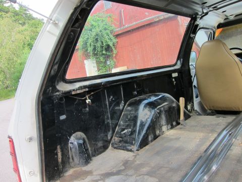 1987 Dodge 1500 - The interior of a 1987 Dodge 1500 pickup truck, viewed from the rear passenger side.