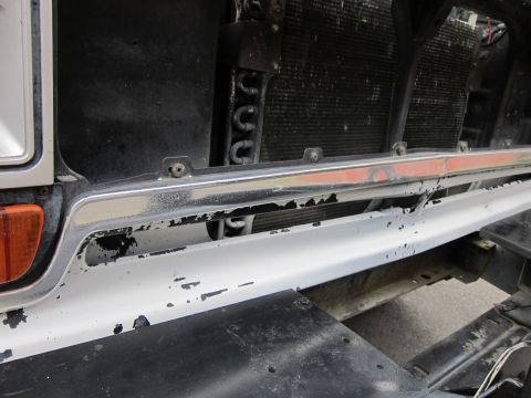 1987 Dodge 1500 - Front view of a vehicle's bumper and grille area, showing signs of wear and tear.