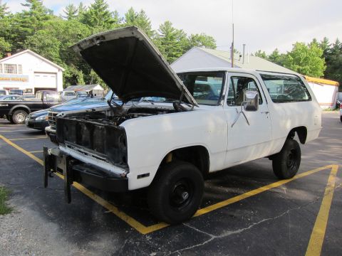 1987 Dodge 1500 - White 1987 Dodge Ramcharger with its hood open, parked in a lot with other vehicles.