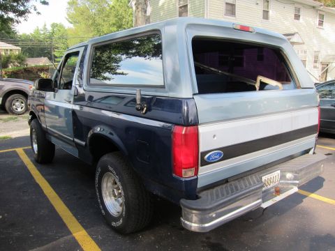 1987 Dodge 1500 - The rear of a two-tone blue and gray Ford Bronco is shown parked in a lot. The license plate is visible.