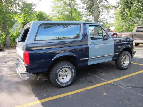 1987 Dodge 1500 - This two-tone blue Ford Bronco, likely from the early 1990s, is seen from a three-quarter front angle.