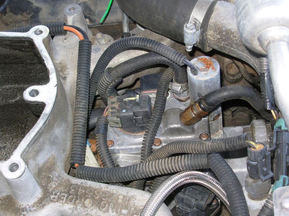 My real goal is the PMD (FSD) on the other (driver's) side of the Injection Pump (IP), barely visible above the pink heat-transfer gasket.  Its connector faces rearward, with the locking catch on the driver's (outboard) side.