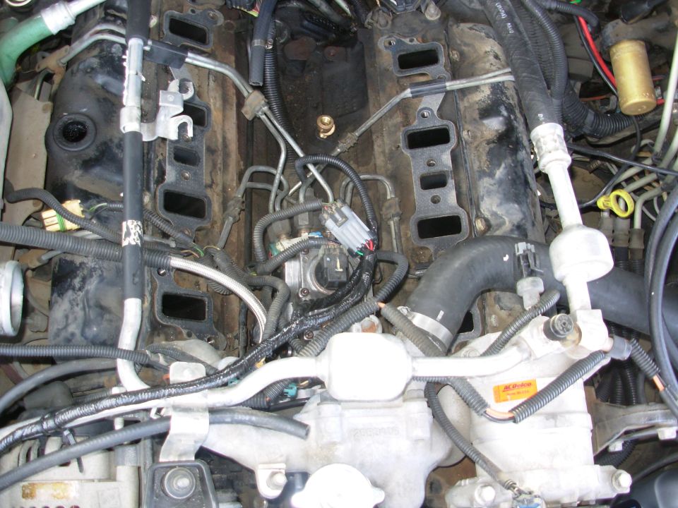 I used 1/2" split loom, which is actually too small for 5 16ga wires.  But it's on & taped up with real wiring harness tape (not electrical tape), so it should be fine.  It's zip-tied to the A/C hard line to keep it away from the pullies.

Cover the intake ports on the heads so nothing can fall inside.  I was lucky.
