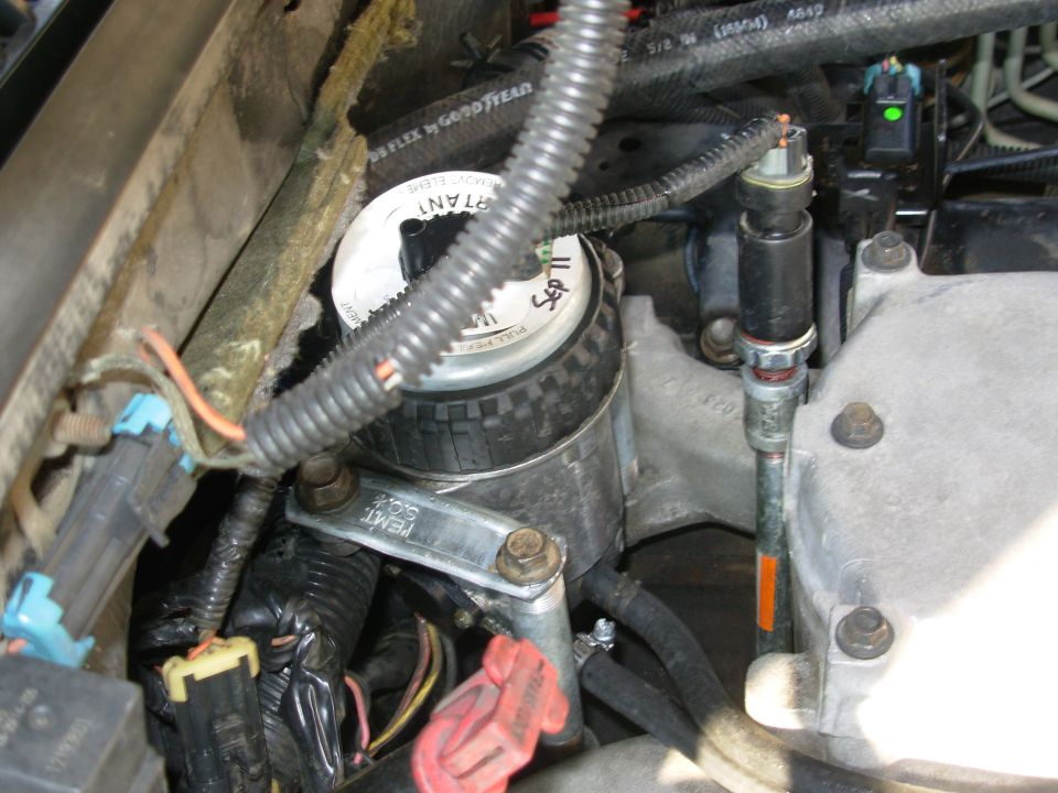 The short bolt in the FFM is one of its originals, with a spare nut.  The strap is necessary to rotate the FFM so the outlet & drain nipples clear the back of the intake.

Turns out, raising the OPS was a BAD move.  The lower elbow cracked at the block after a few months, and leaked for a few more before I got around to messing with it.  Fortunately, due to the other mods I did, it was relatively easy to extract the broken end & put the OPS back in the block.

Fuel filter is a Mann from [url=http://www.amazon.com/gp/product/B0027EVCEK/]Amazon[/url].