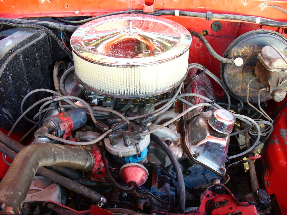 V8 engine bay showing carburetor, air filter, distributor, and wiring