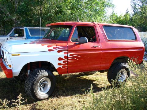 1979 Ford Bronco - This lifted 1978 Ford Bronco features a striking red and white paint scheme with flame decals.