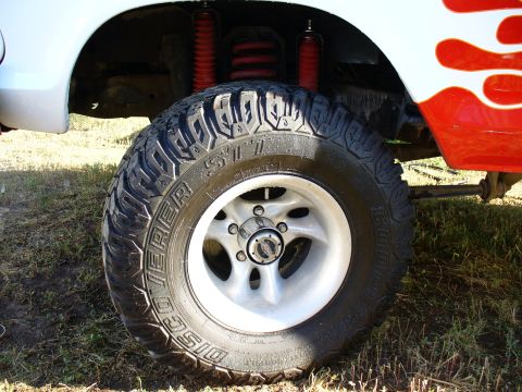 1979 Ford Bronco - Off-road tire and suspension details on a custom truck with flame graphics.
