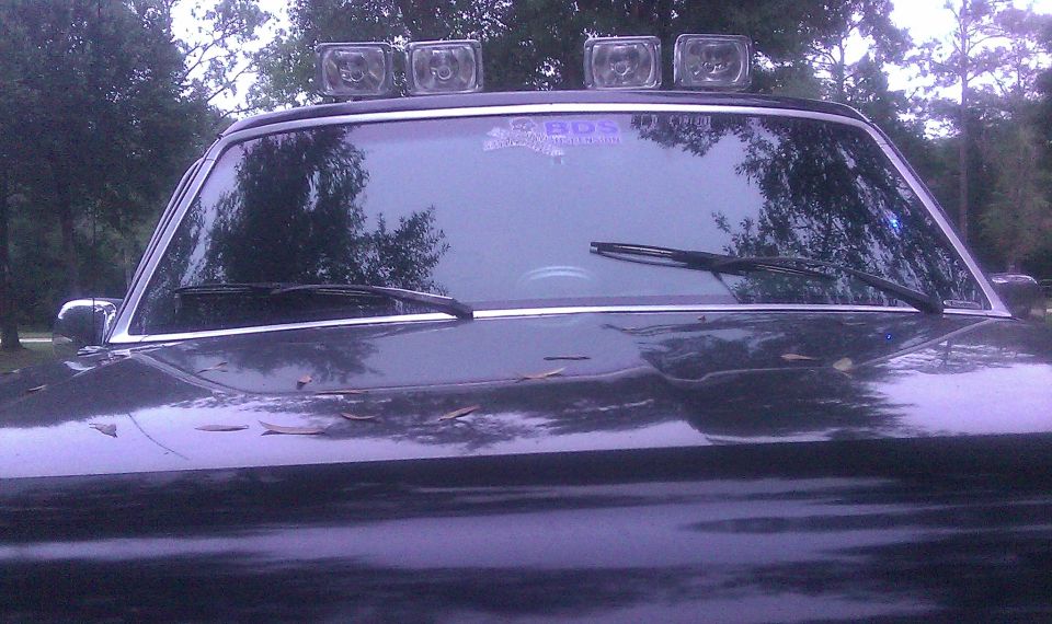 Dark SUV front view with four roof lights and BDS sticker on windshield