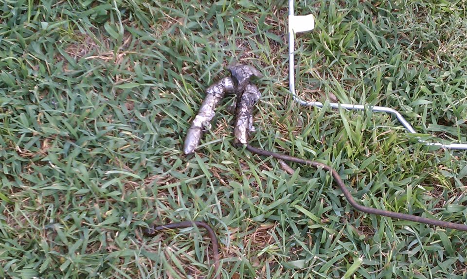 Metal car part on grass with Supermotors logo