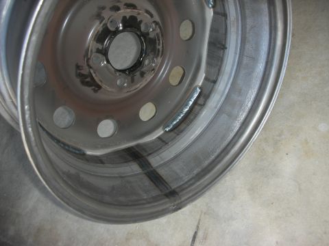 2004 Ford Crown Victoria - This is a close-up view of a steel wheel that has been modified with welds on its rim.