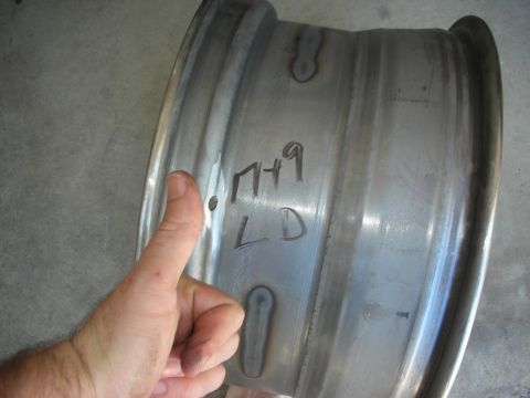 2004 Ford Crown Victoria - A close-up of a metal wheel with handwritten markings and a thumb giving a thumbs up.