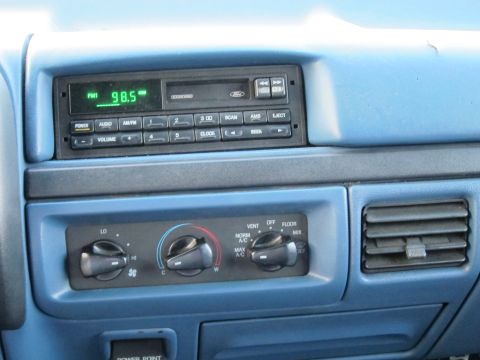 2001 Ford Crown Victoria - The interior of a vehicle shows the radio and climate control panel with blue trim.