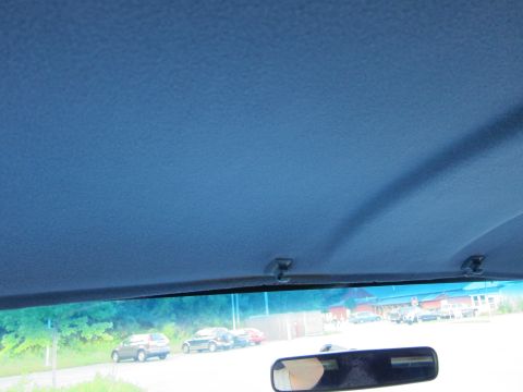 2001 Ford Crown Victoria - View from inside a vehicle, looking out through the windshield at parked cars and buildings.