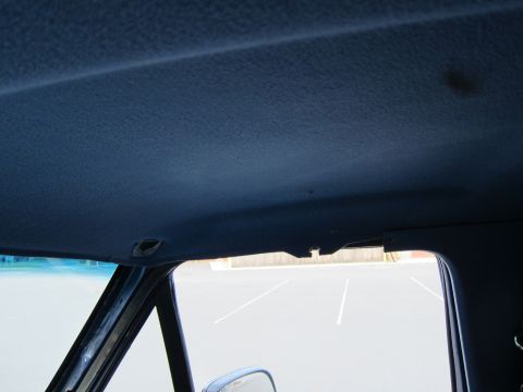 2001 Ford Crown Victoria - Interior view of a vehicle's blue headliner and a portion of the windshield looking out at a parking lot.