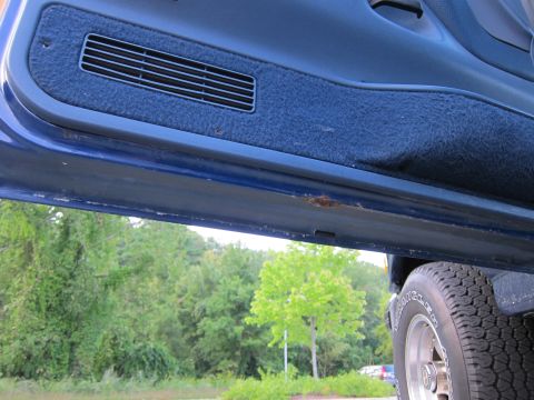 2001 Ford Crown Victoria - Interior view of a car door, revealing a vent and some rust on the lower panel.