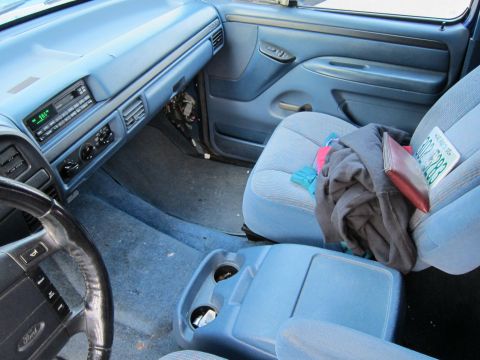 2001 Ford Crown Victoria - Interior view of a blue truck, showing the dashboard, seats, and a license plate.