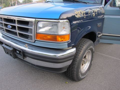 2001 Ford Crown Victoria - Front corner view of a blue and dark blue two-tone Ford truck, a chrome grille and bumper.