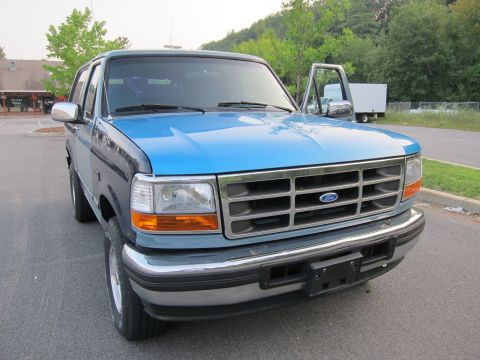 2001 Ford Crown Victoria - This is a blue and gray Ford F-150 truck with the driver's door ajar.