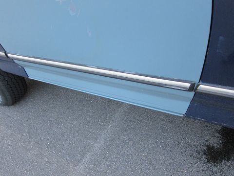 2001 Ford Crown Victoria - Close-up view of a two-tone car's side panel, showing a light blue door and a dark blue fender.