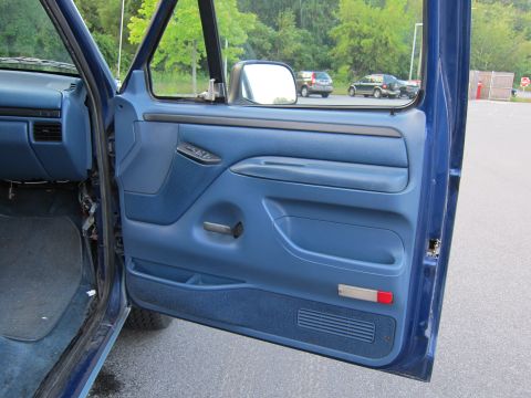 2001 Ford Crown Victoria - Interior view of a blue truck door, with other vehicles in the background.