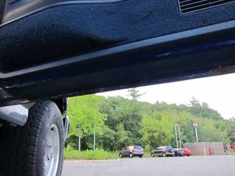 2001 Ford Crown Victoria - View from inside a vehicle looking out at parked cars and trees.