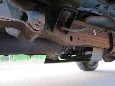 2001 Ford Crown Victoria - The underbody of this vehicle shows significant rust on the frame and suspension parts.
