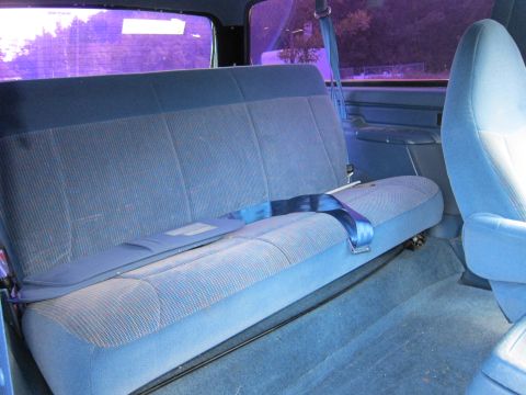 2001 Ford Crown Victoria - The interior of a vehicle shows a blue fabric rear bench seat with a blue seatbelt.